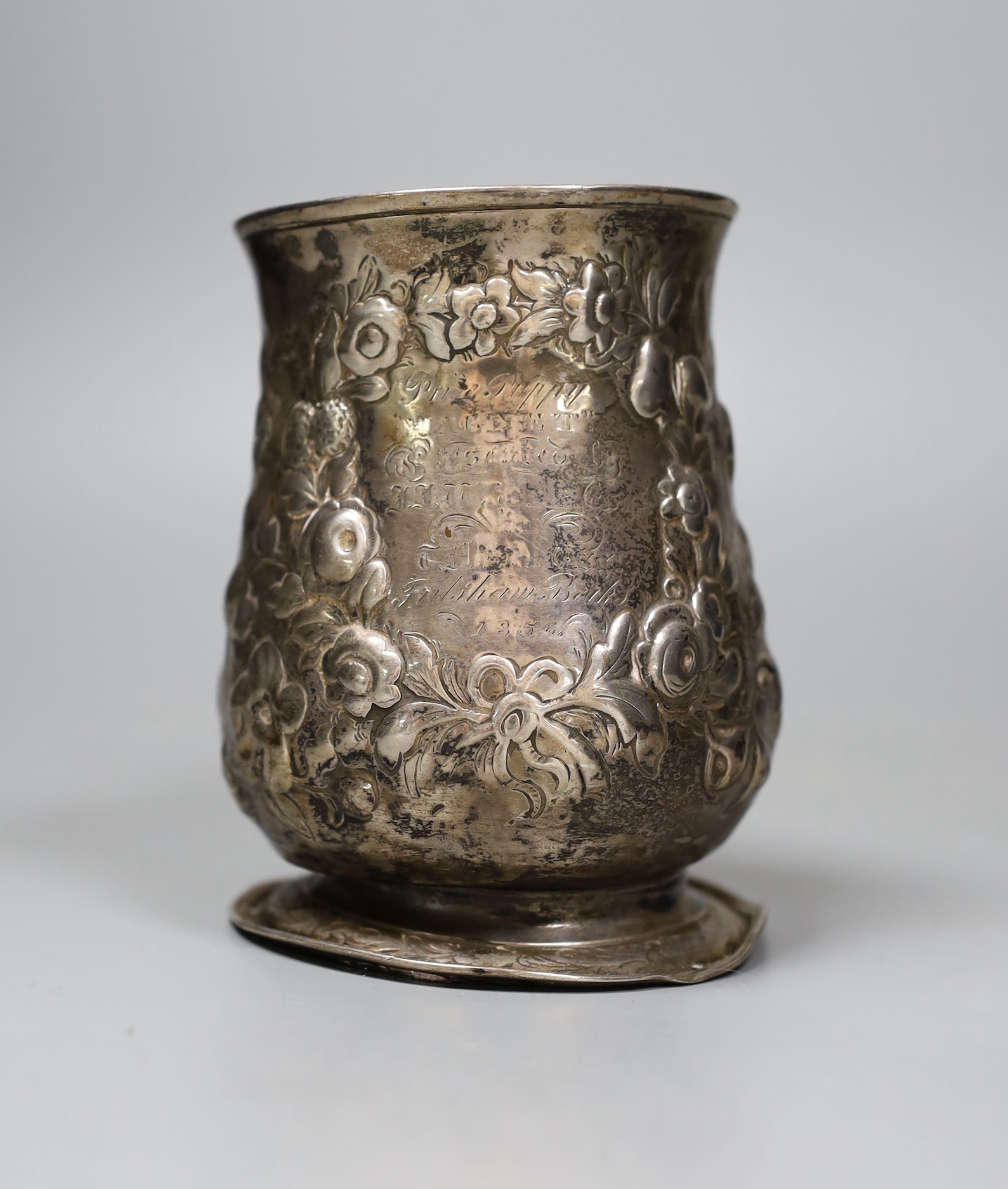 An early George III silver mug, with later-embossed floral detail, London 1762, 12cm.